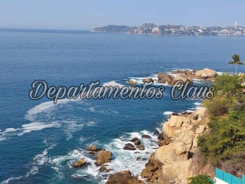 a view of the ocean and a rocky coastline at Suite Claus in Acapulco