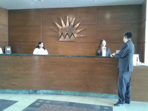 a man in a suit standing at a reception desk at Hotel Chagall in Copiapó