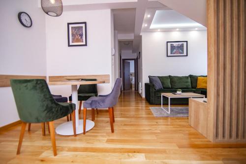 a living room with a couch and a table and chairs at Titova Vila Zlatibor in Zlatibor
