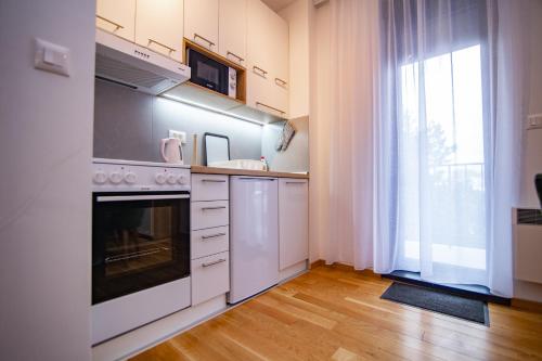 a kitchen with white appliances and a large window at Titova Vila Zlatibor in Zlatibor