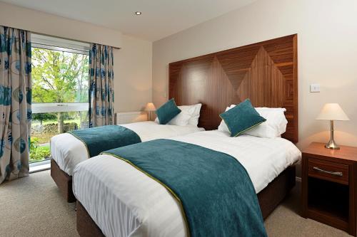two beds in a hotel room with a window at The View at the White Horse Woolley Moor in Clay Cross