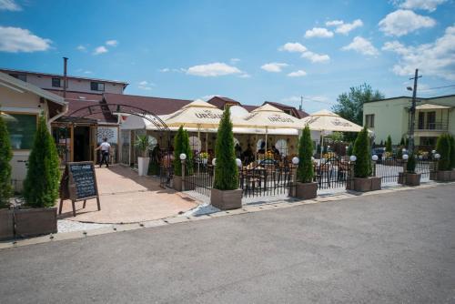 a street with a restaurant with umbrellas and a fence at Seva Hotel Health Club in Campina