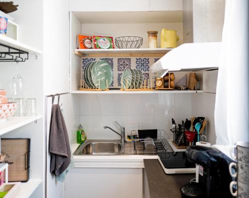 a kitchen with a sink and a dish rack at Warm Studio en duplex proche Paris et Disney in Neuilly-Plaisance