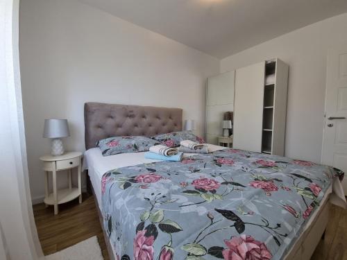 een slaapkamer met een bed met een bloemdekbed bij Apartments Manuel in Rab