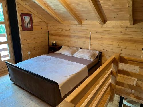 a bedroom with a bed in a wooden cabin at Cottage Ravna Rijeka in Bijelo Polje