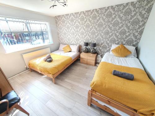 a bedroom with two beds and a window at Wetherne House, Beautiful Home, Parking Garden WiFi Self Check-in in Luton
