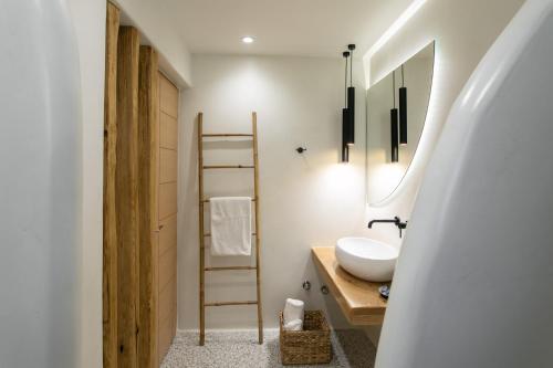 a bathroom with a white sink and a ladder at Iades Studios & Apartments in Agia Anna Naxos