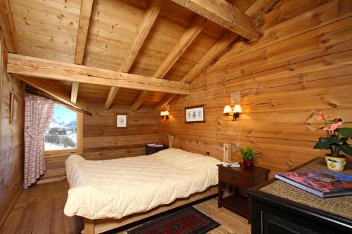 a bedroom with a bed in a log cabin at Odalys Chalet Melusine in L'Alpe-d'Huez