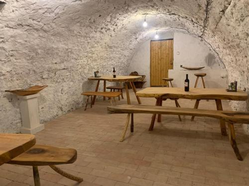 una stanza con tavoli e panche in legno in una grotta di Loft Pihenő és Wellness Ház a Balatonfüred