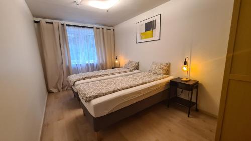 um pequeno quarto com 2 camas e uma janela em Your Space in Jurmala em Jūrmala