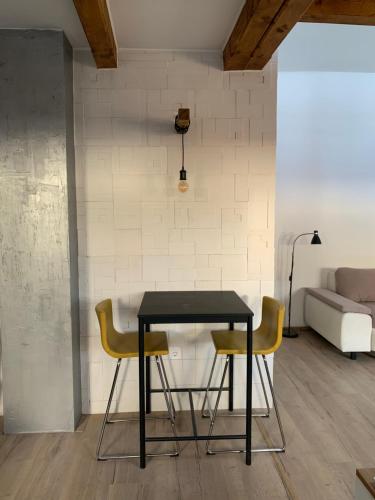 a black table with two chairs and a couch at Loft Pihenő és Wellness Ház in Balatonfüred