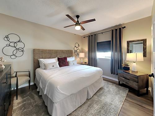 ペンサコーラ・ビーチにあるEmerald Isle #501の白いベッドと天井ファンのある寝室