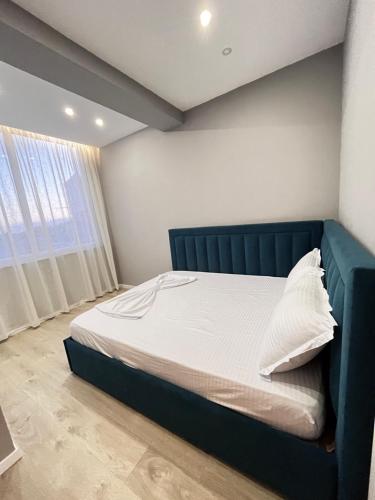 łóżko z niebieskim zagłówkiem w sypialni w obiekcie Belix Seaview Apartments w Durrës