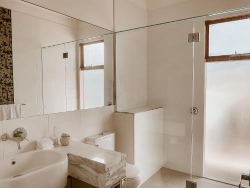 a bathroom with a sink and a toilet and a mirror at Byron Butter Factory Apartments in Byron Bay