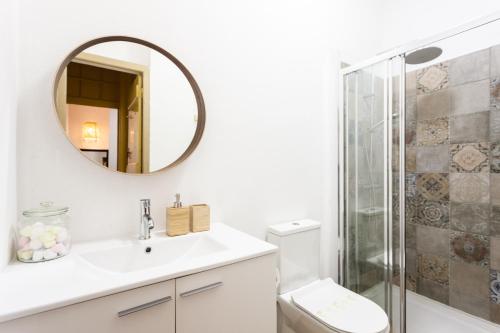 ein weißes Badezimmer mit einem Waschbecken und einem Spiegel in der Unterkunft Yellow Tiles in City Center in Lissabon
