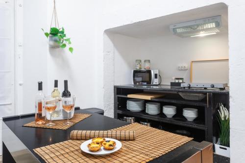 a kitchen with a table with a plate of food and glasses of wine at Yellow Tiles in City Center in Lisbon