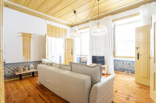 a living room with a couch and a tv at Yellow Tiles in City Center in Lisbon