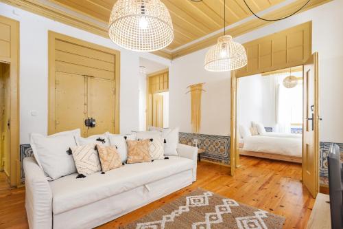ein Wohnzimmer mit einem weißen Sofa und ein Schlafzimmer in der Unterkunft Yellow Tiles in City Center in Lissabon