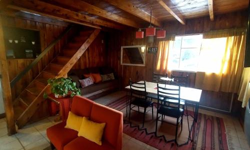 una habitación con mesa y sillas en una cabaña en La Avutarda en San Carlos de Bariloche