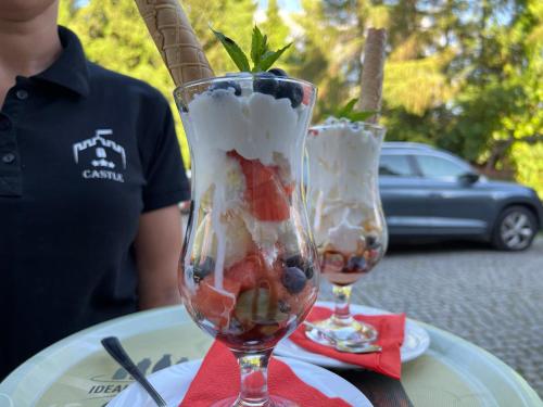 two glasses of ice cream and fruit on a table at Hotel i Restauracja Castle in Bystrzyca Kłodzka