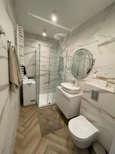 a bathroom with a toilet and a sink and a mirror at Balticus Apartament 2 pokoje, 5-piętro, klimatyzacja, widok na morze, duży balkon, garaż, internet in Międzyzdroje