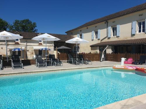 a swimming pool with chairs and umbrellas at Gites la Charrue in Monsec