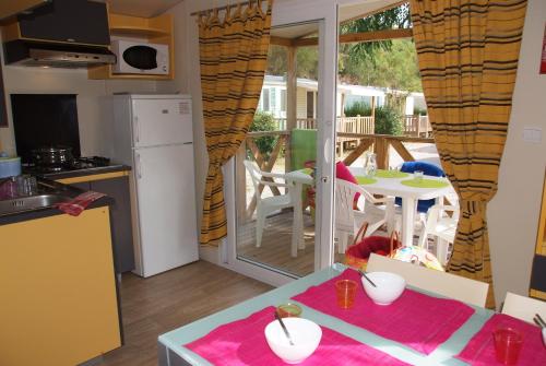 a small kitchen with a table and a balcony at Camping Vallée du Paradis in Agay - Saint Raphael