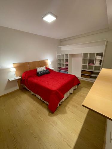 een slaapkamer met een bed met een rode deken bij NUEVO Y LUMINOSO Departamento 2 Ambientes in Mar del Plata