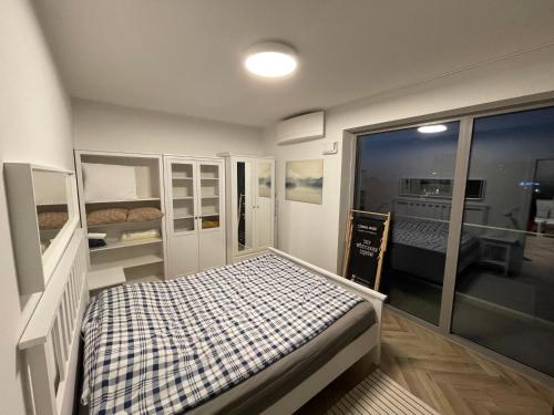 a small room with a bed and a window at Balticus Apartament 2 pokoje, 5-piętro, klimatyzacja, widok na morze, duży balkon, garaż, internet in Międzyzdroje