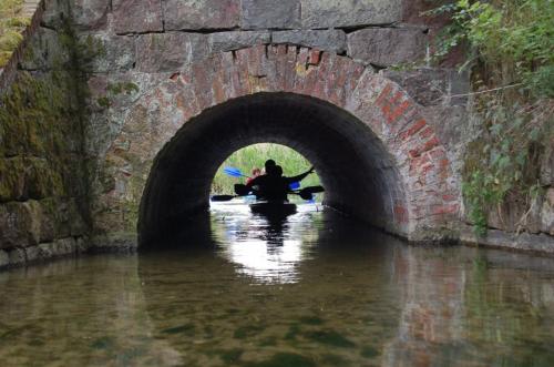 deux personnes sont assises dans un tunnel dans l'eau dans l'établissement Gościniec Borne Sulinowo - Była Baza Wojskowa, à Borne Sulinowo