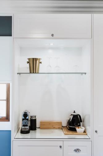 a kitchen with white cabinets and a counter top at Enfield House Mudgee in Mudgee