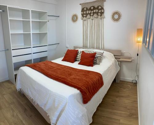 a bedroom with a large white bed with red pillows at La Capucine in Montauban