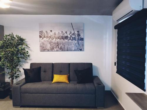 a couch in a living room with a picture on the wall at Consulado Americano a 5 minutos D3 in Ciudad Juárez