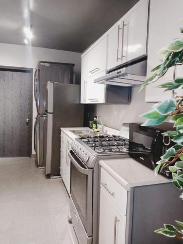 a kitchen with a stove and a refrigerator at Consulado Americano a 5 minutos D3 in Ciudad Juárez