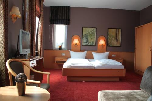 a hotel room with a bed and a tv at Buskes Hotel Steinförde in Wietze