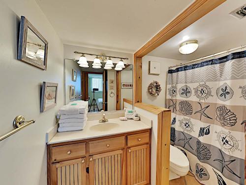 a bathroom with a sink and a toilet and a mirror at Santa Rosa Dunes #952 in Pensacola Beach