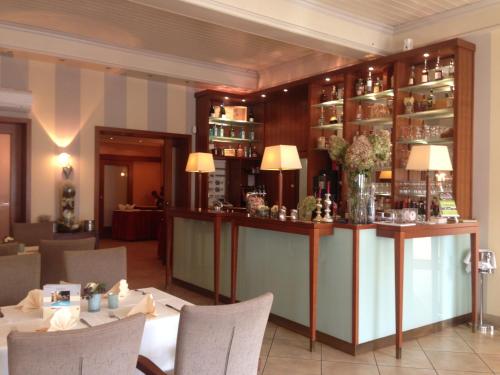 a restaurant with a bar with tables and chairs at Buskes Hotel Steinförde in Wietze
