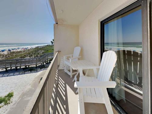 a balcony with white chairs and a view of the beach at Villas Capri #9 in Fort Walton Beach