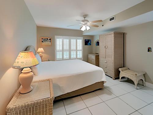 1 dormitorio con cama, lámpara y silla en Sea Oats #201, en Fort Walton Beach