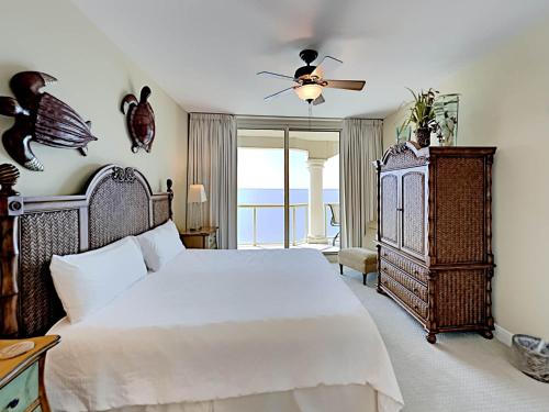 a bedroom with a large white bed and a balcony at Portofino Island Resort #4-1309 in Pensacola Beach