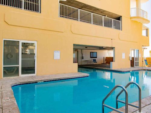 a swimming pool with blue water in front of a building at Island Royale Penthouse #405 in Gulf Shores