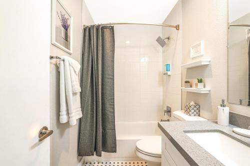a white bathroom with a shower and a toilet at LaRocco On Turney Biltmore in Phoenix