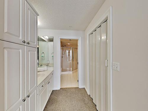 a white bathroom with a sink and a mirror at The Pearl of Navarre #805 in Navarre