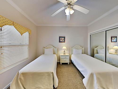 two beds in a bedroom with a ceiling fan at The Pearl of Navarre #805 in Navarre
