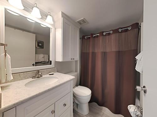 a bathroom with a sink and a toilet and a mirror at Perdido Skye #32 in Perdido Key