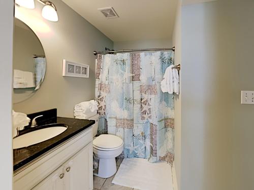 a bathroom with a shower curtain and a toilet at Dory #E in Perdido Key