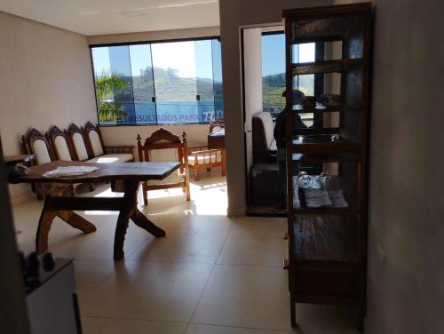 a living room with a wooden table and chairs at Canastra Flat Hospedagem in Vargem Bonita