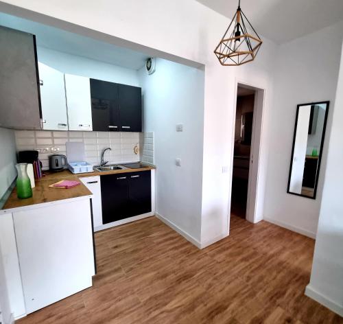 Eine Küche mit weißen Schränken und Holzboden in der Unterkunft Oasis in Los Cristianos