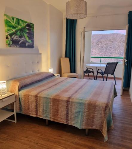 a bedroom with a bed and a table and chairs at Oasis in Los Cristianos