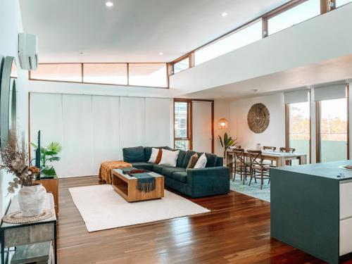 a living room with a couch and a table at Byron Butter Factory Apartments in Byron Bay